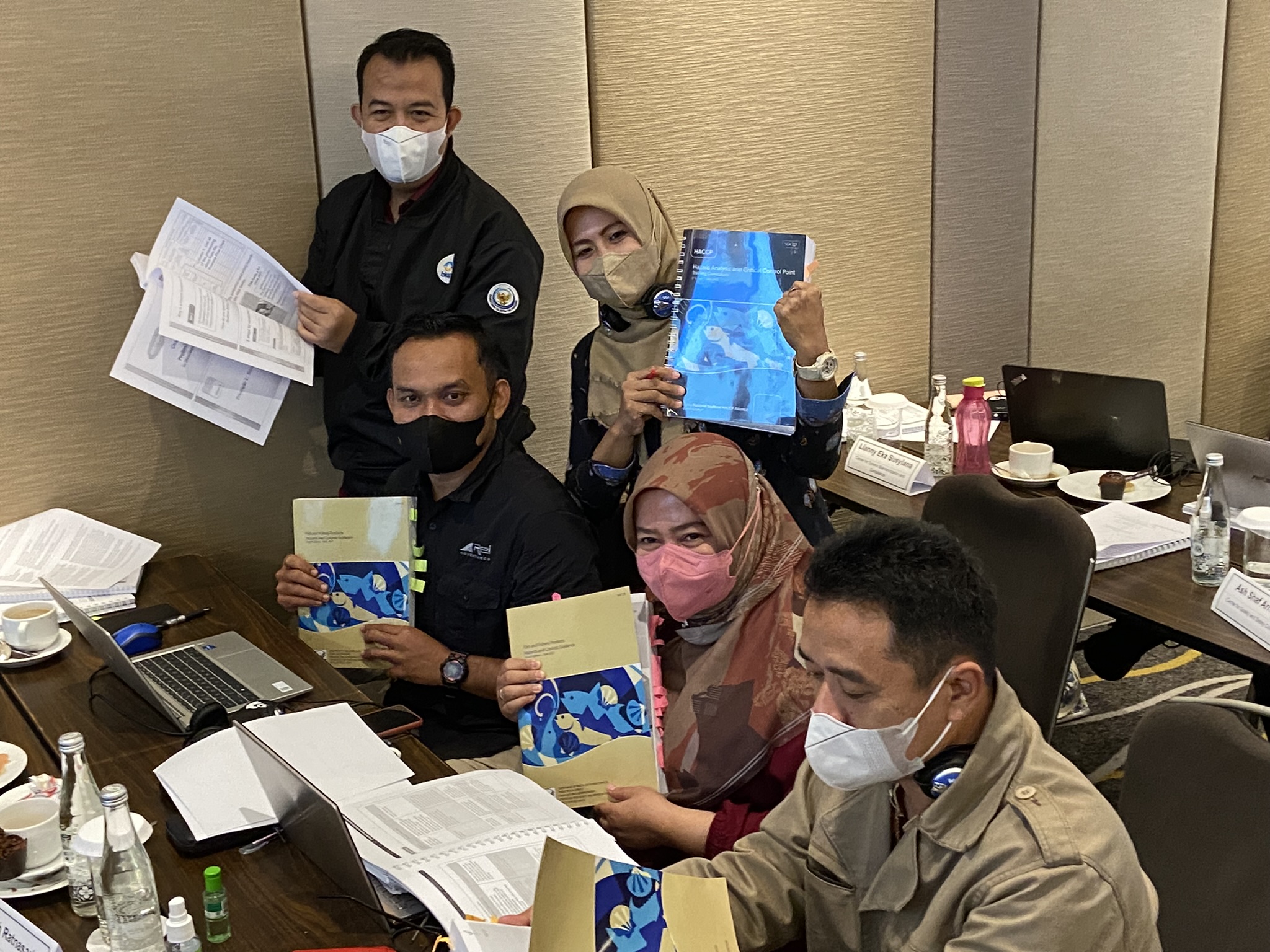 Indonesian participants holding the Fish and Fishery Products Hazards and Controls Guidance manual.